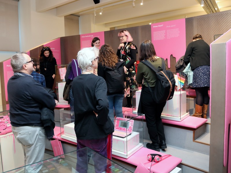 Visitors looking at exhibits from the "Who owns Pink?" exhibition: 